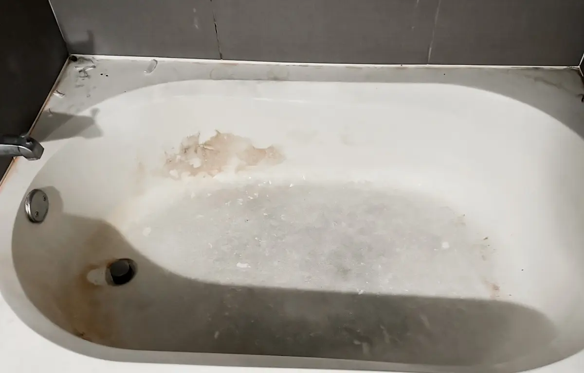 Bañera con suciedad y manchas acumuladas antes de la limpieza