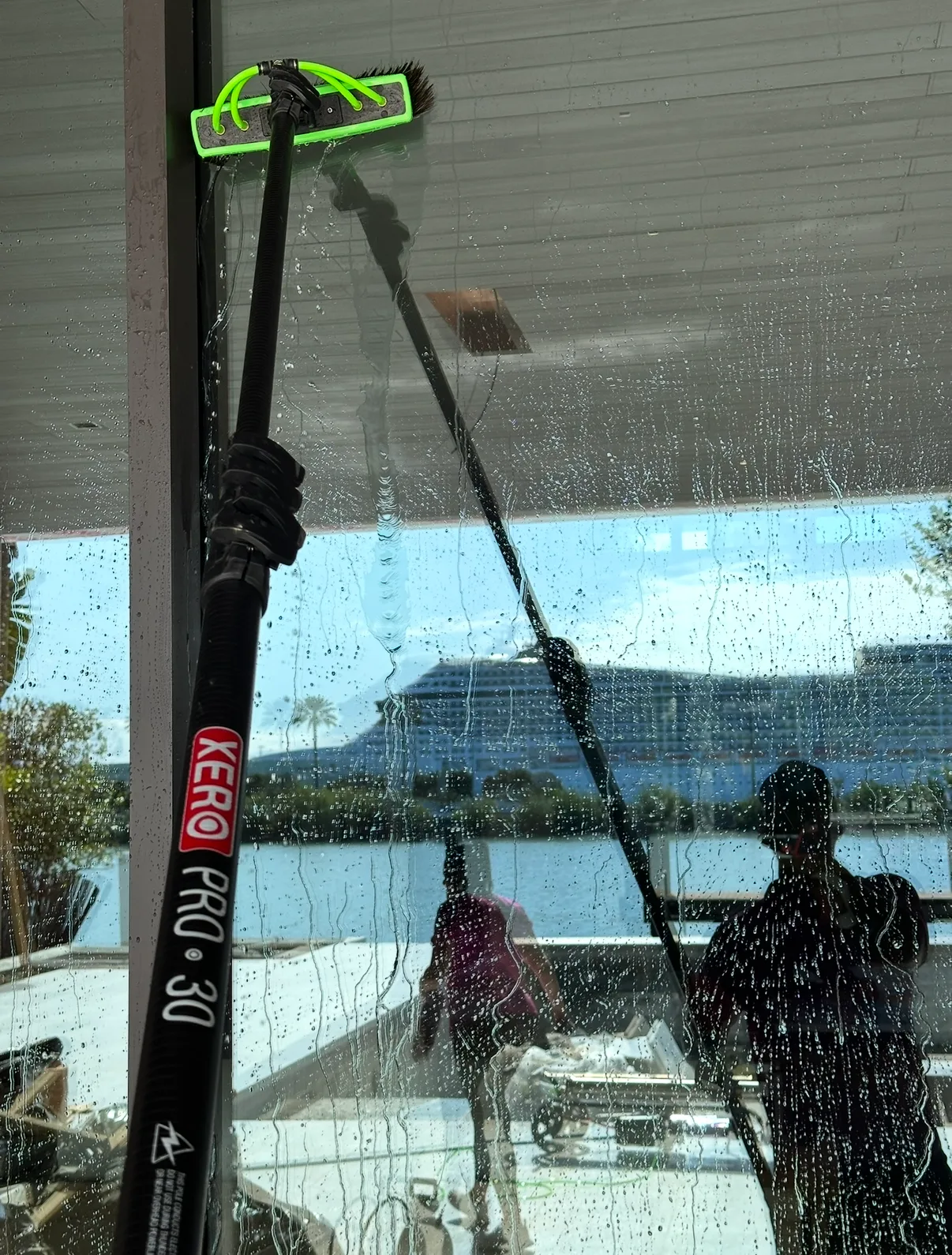 Water-fed pole brush washing a glass pane at a Miami Beach waterfront home